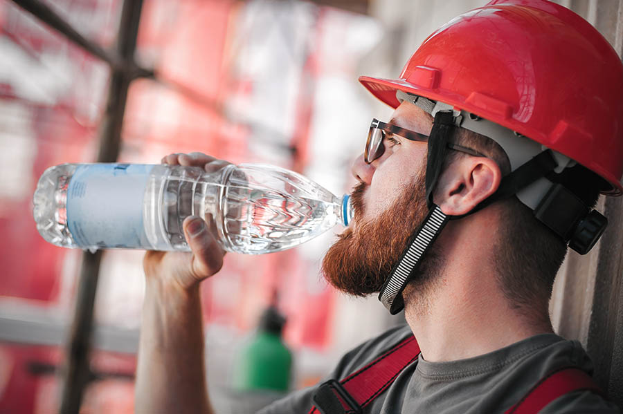 male construction worker drinking water