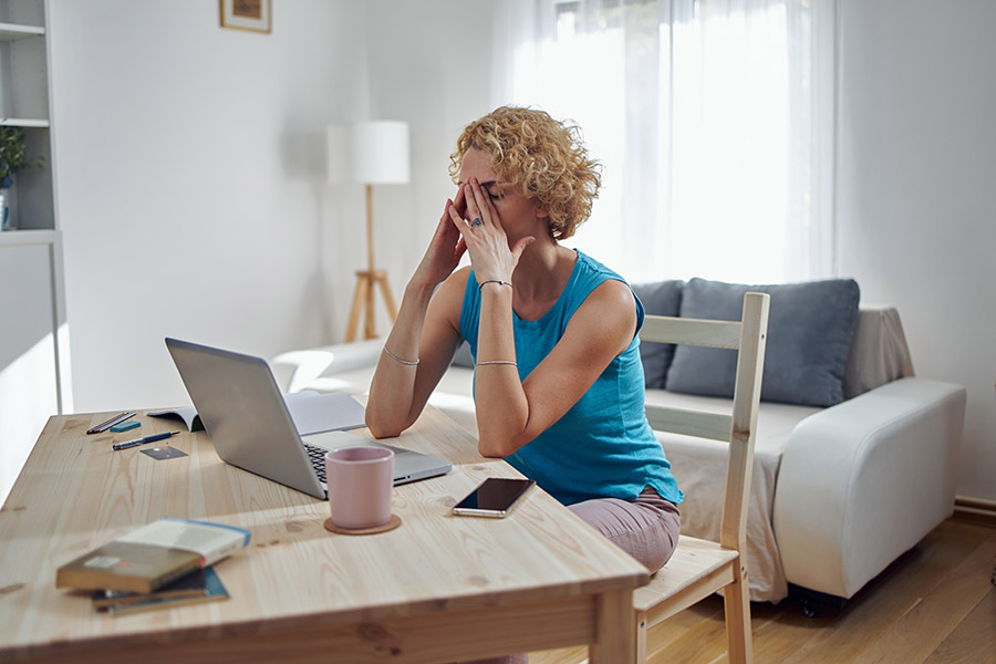 woman holding head from migraine pain